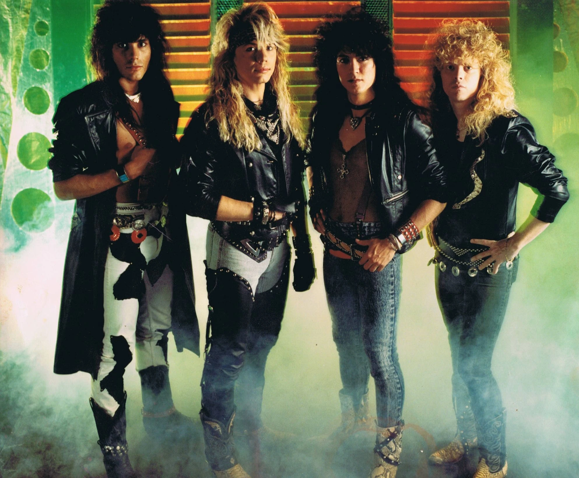 Four members of Banshee in an original promo photo against green walls and red shutters